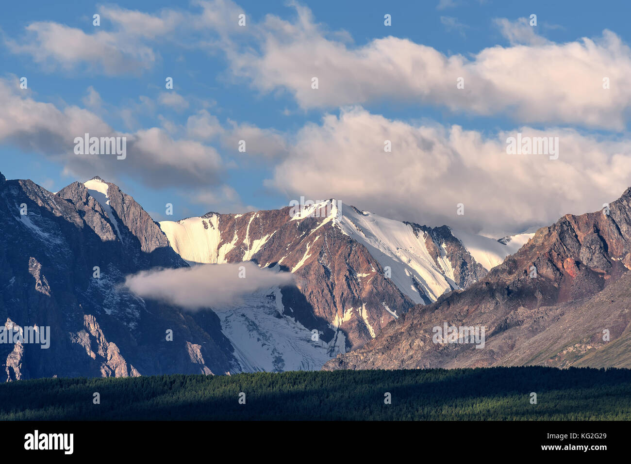 Scenic view with snow-capped mountain peaks in beautiful fluffy clouds ...