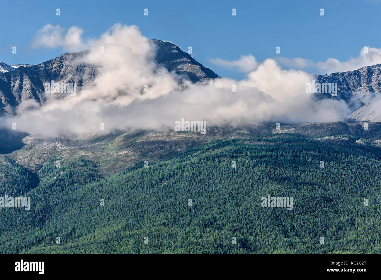 Scenic view with snow-capped mountain peaks in beautiful fluffy clouds ...