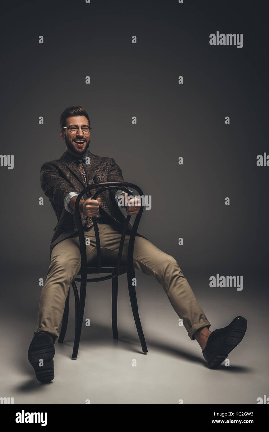 man in suit sitting on chair backwards Stock Photo Alamy