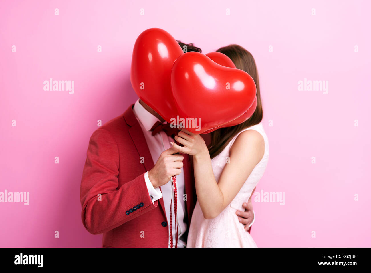Couple kissing behind balloons Stock Photo