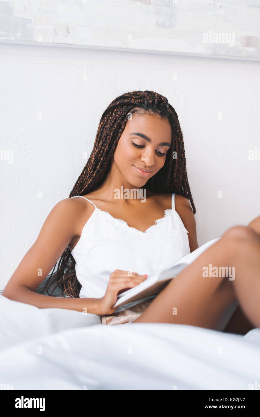 woman reading book in bed Stock Photo