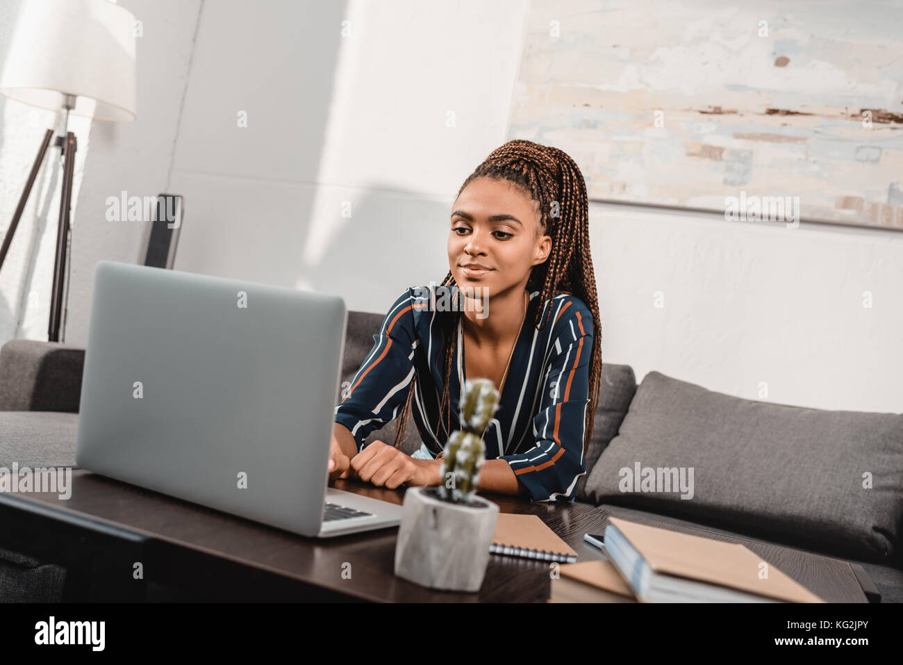 woman using laptop on couch Stock Photo - Alamy