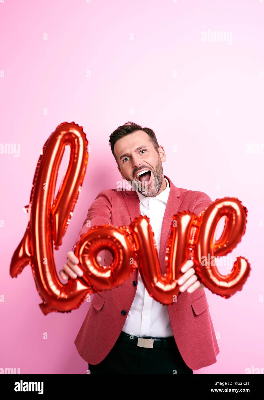 Man with helium balloon shouting love you Stock Photo
