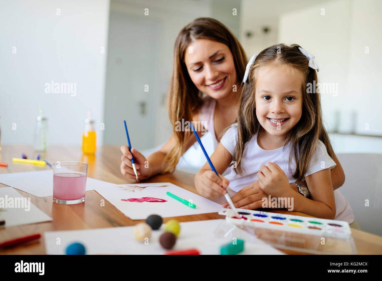 Little girl painting with her mother at home Stock Photo - Alamy