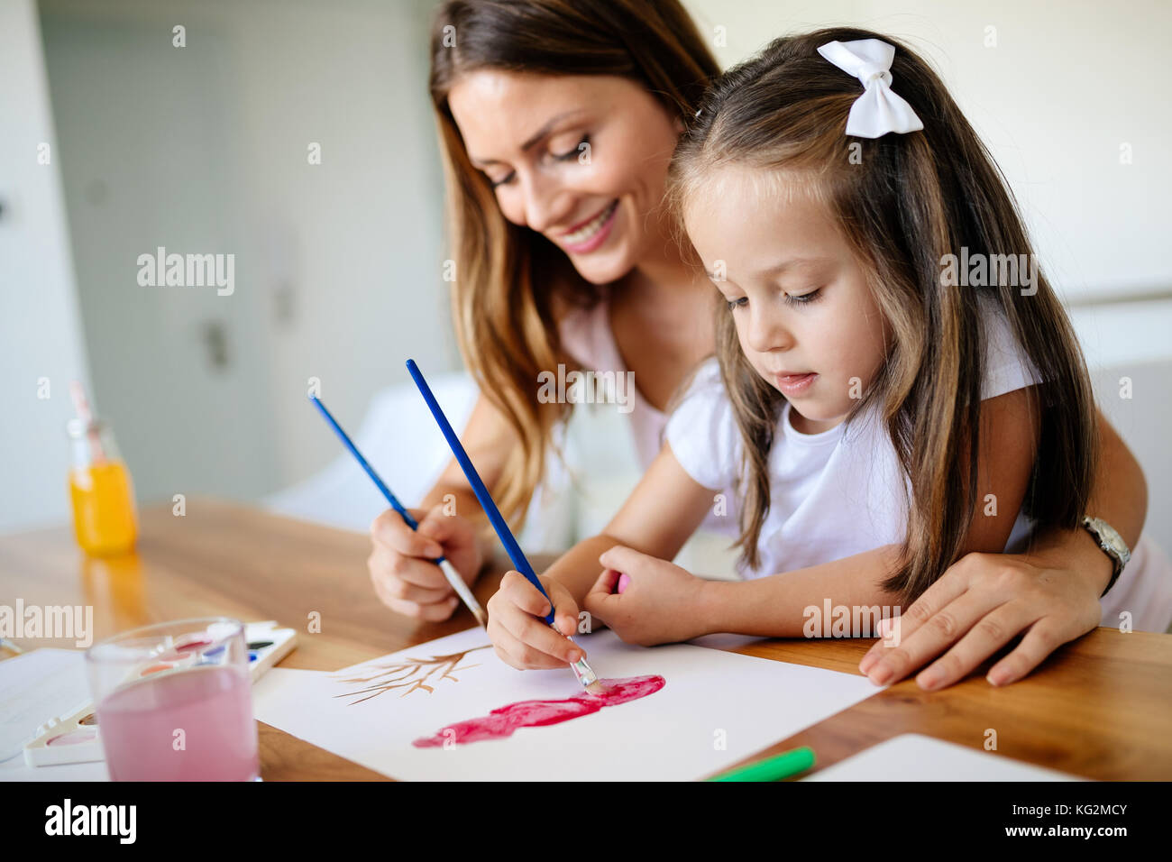 Little girl painting with her mother at home Stock Photo - Alamy