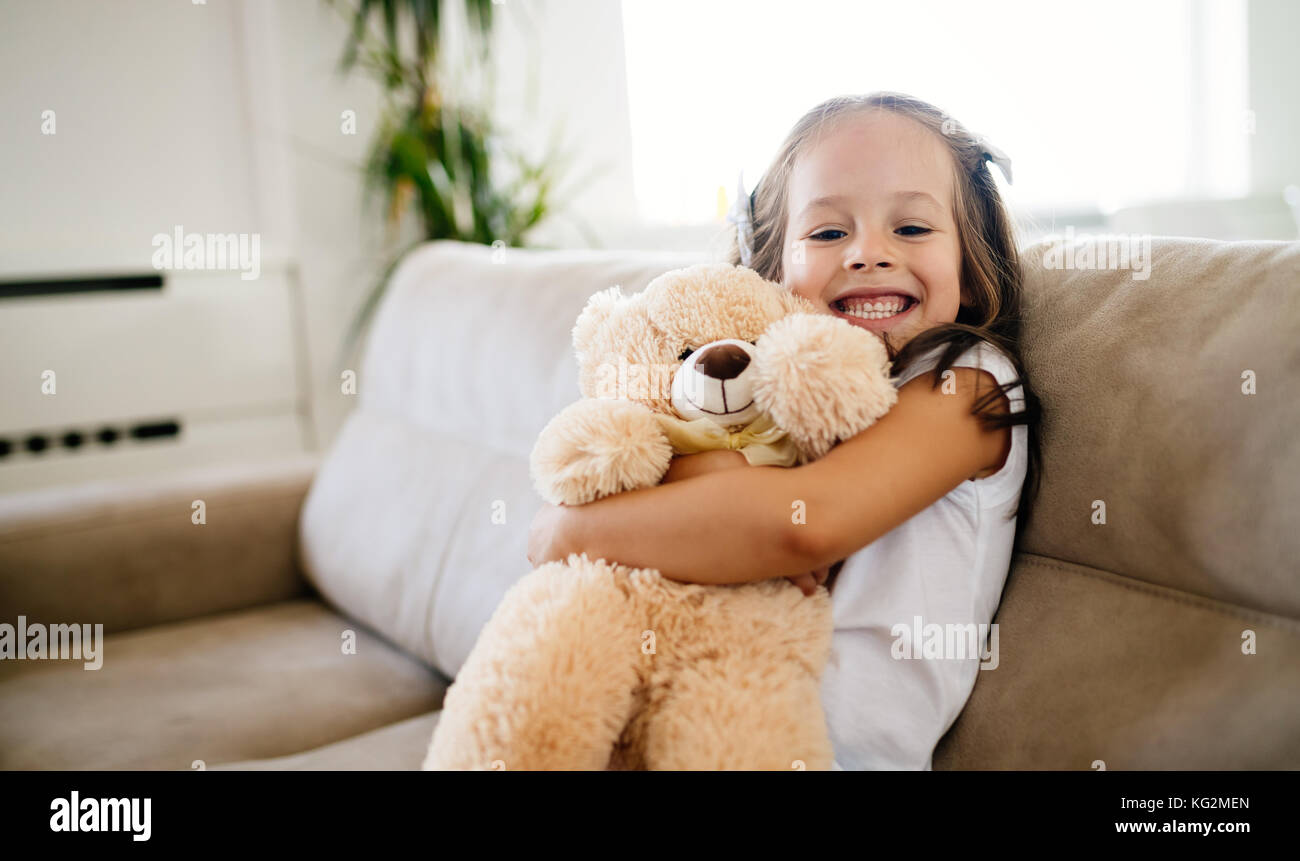 Cute little girl playing with teddy bear Stock Photo