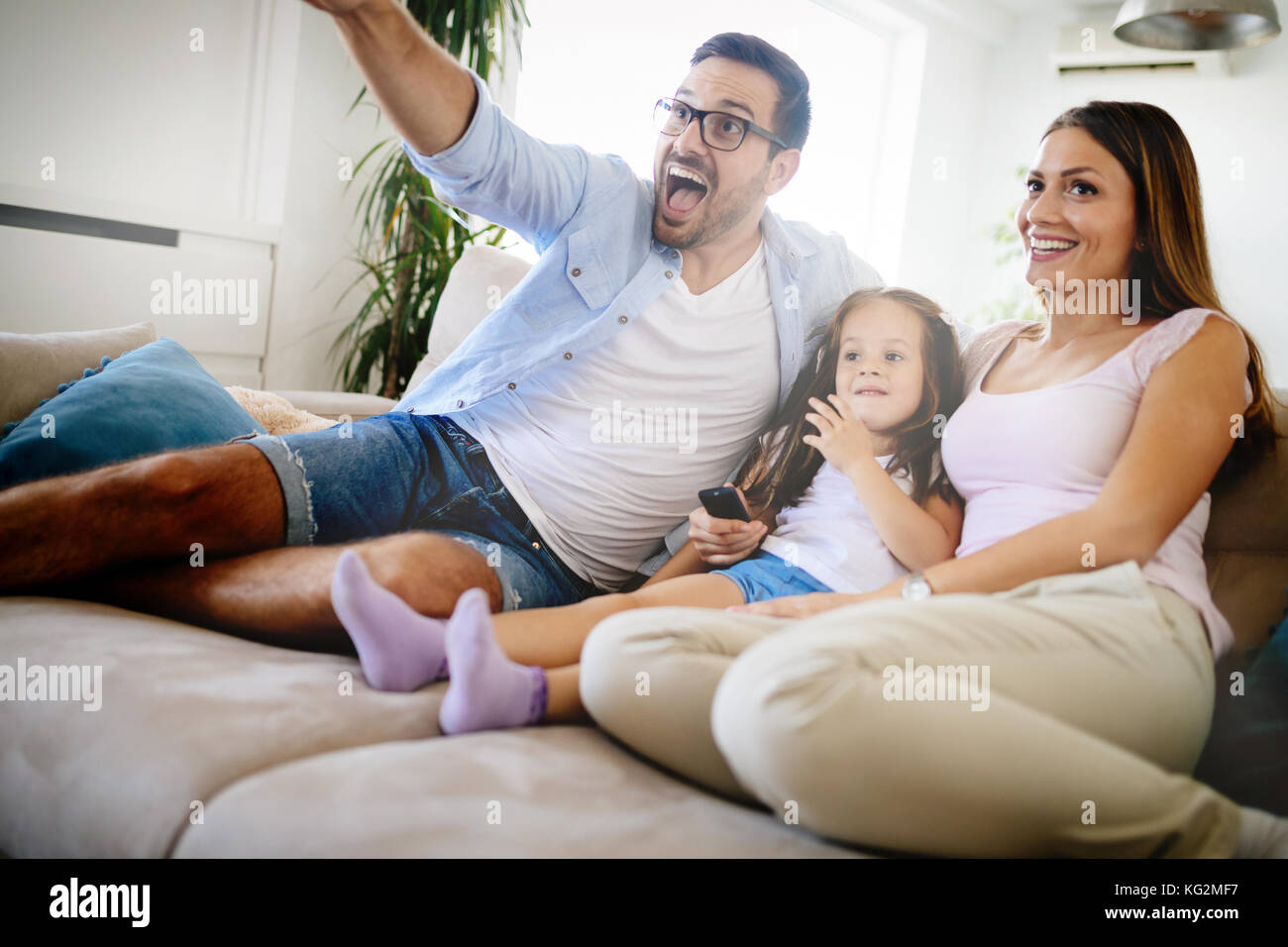 Happy family watching television at their home Stock Photo