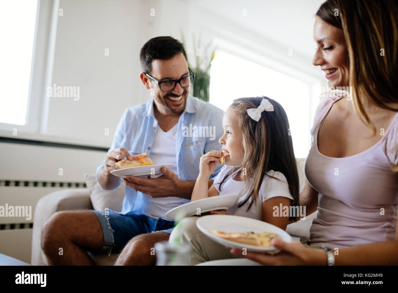 Happy family sharing pizza together at home Stock Photo