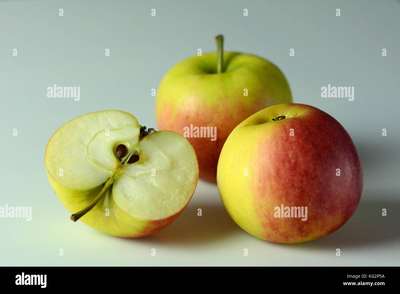Three ripe apples on white background one apple cut in half Stock Photo Alamy