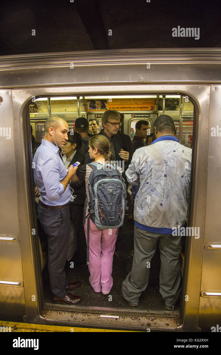 Riders squeeze into an uptown No. 6 subway train at 59th Street on the East Side of Manhattan. New York City. Stock Photo