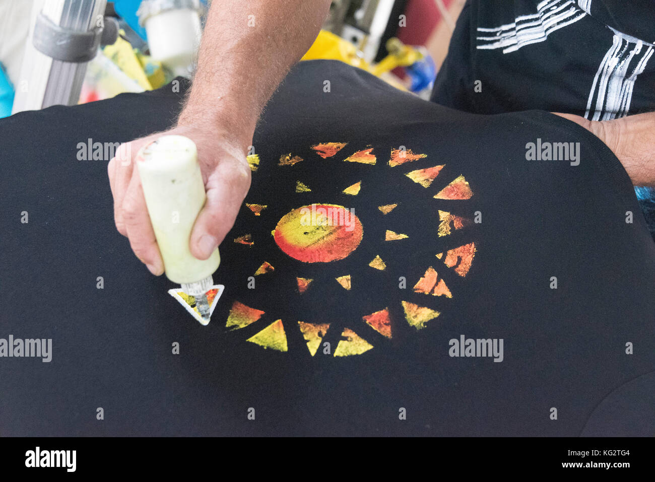 Artist ar work on painting T Shirt at cradt market in Lanzarote Canary Islands. Stock Photo
