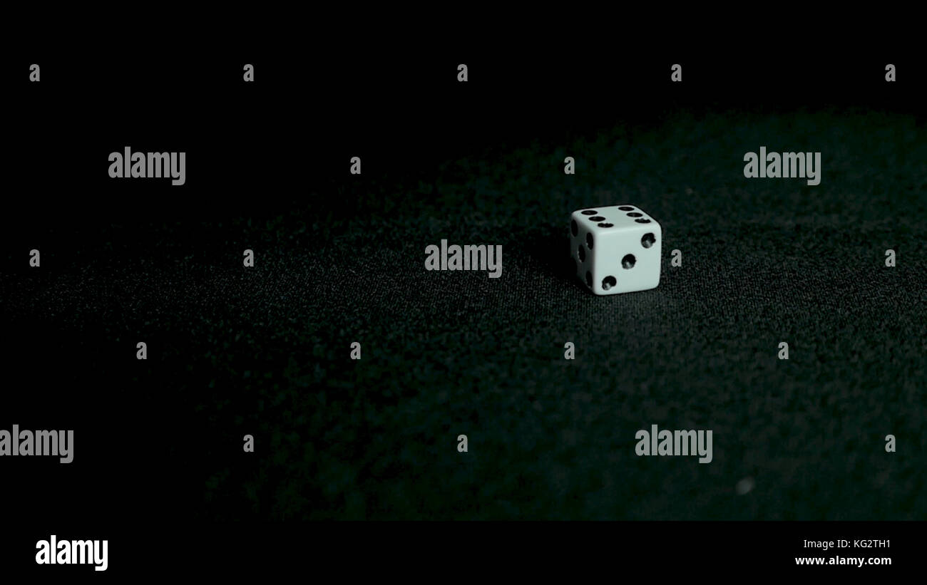 Female hand throwing dice on black background in slow motion. Two