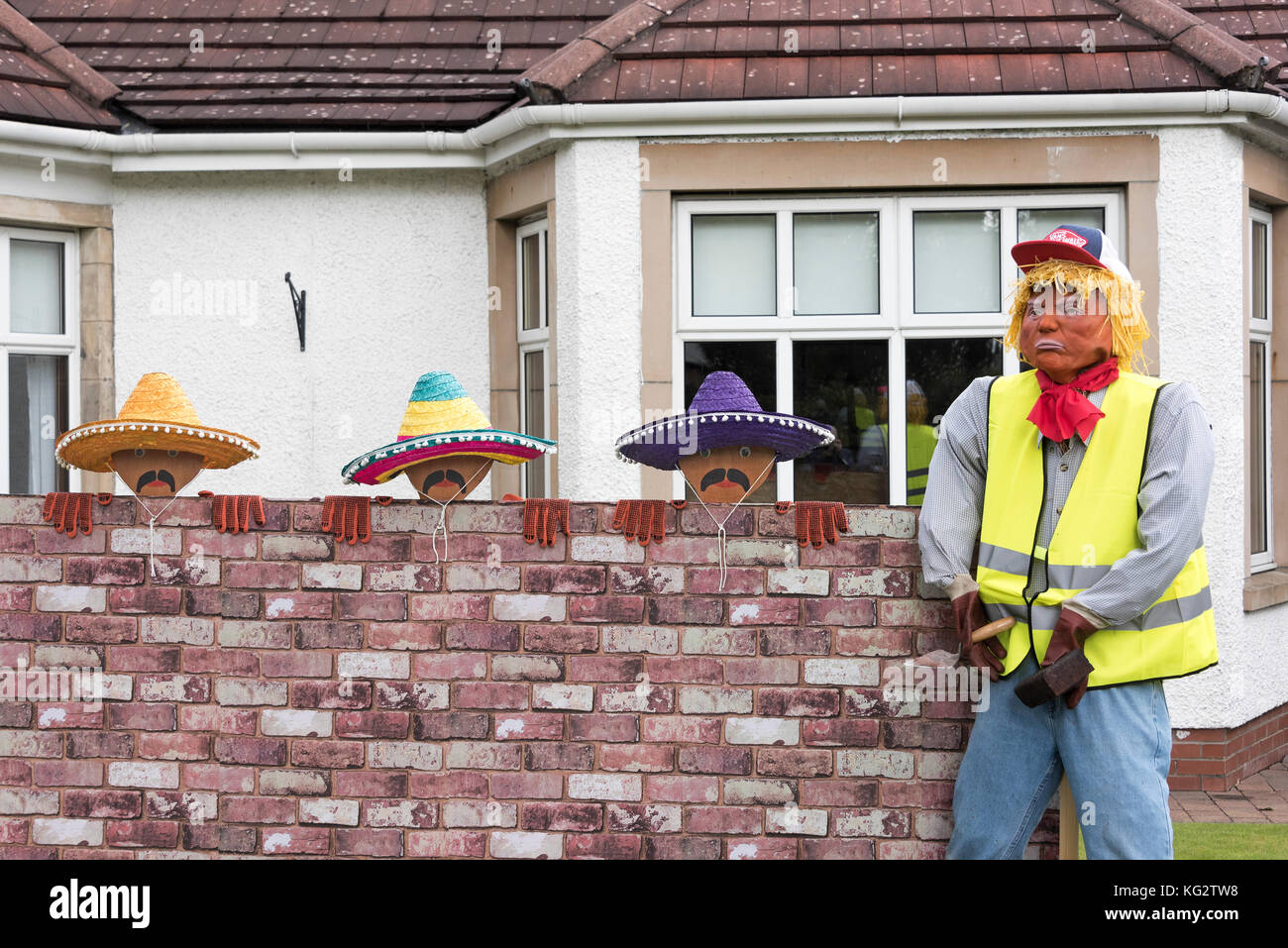 Scarecrow Festival funny exhibit showing President Trump and Mexicans building 'the wall';. Stock Photo