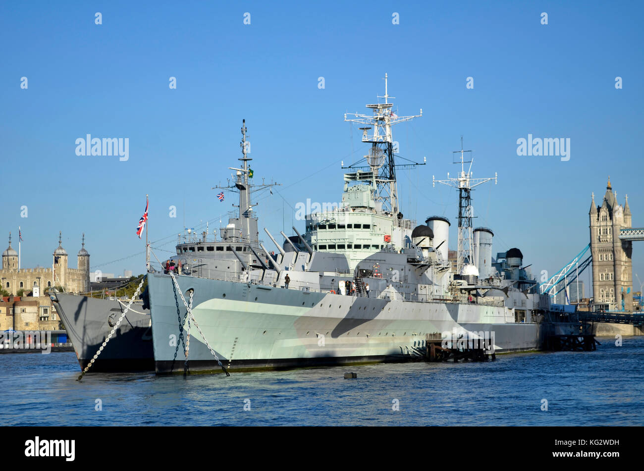 HMS Belfast, River Thames, London, UK. Brazilian Navy U27 training ship moored behind. Tower of London and tower Bridge in background. Stock Photo
