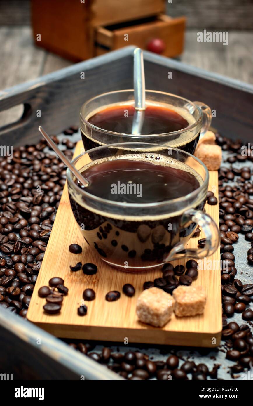 Two cups of coffee,coffee beans and brown lump sugar on wooden ...