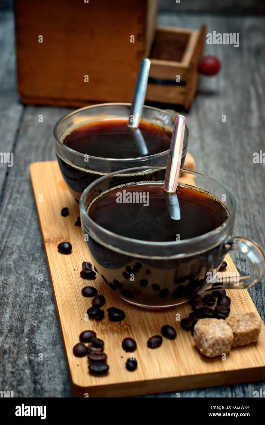 Two cups of coffee,coffee beans and brown lump sugar on wooden ...
