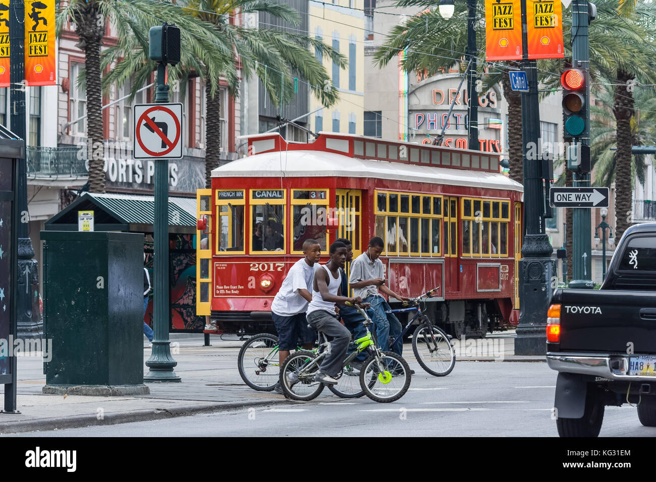 African-American kids crossing Canal Street riding bicycles in New Orleans, Louisiana Stock Photo