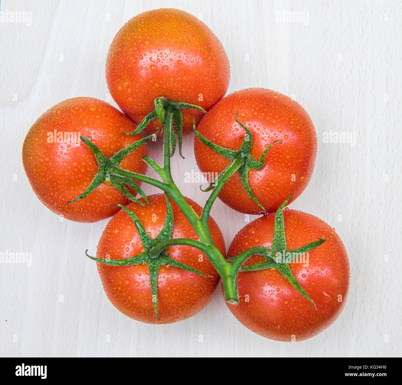Bunch wet, red and ripe tomatoes on cutting board Stock Photo - Alamy