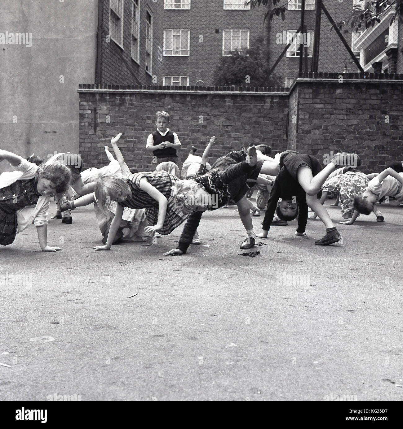 1960s, London, primary school children playing a game outside in the ...