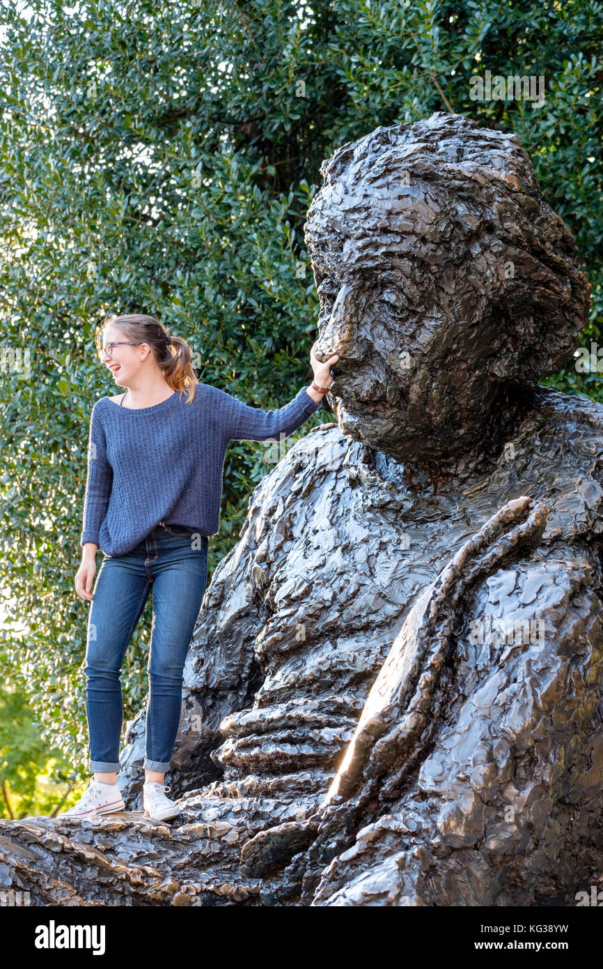 Teenager girl, tourist, rubbing Albert Einstein nose to acquire some of his knowledge, Albert Einsten Memorial, Washington DC, USA. Stock Photo