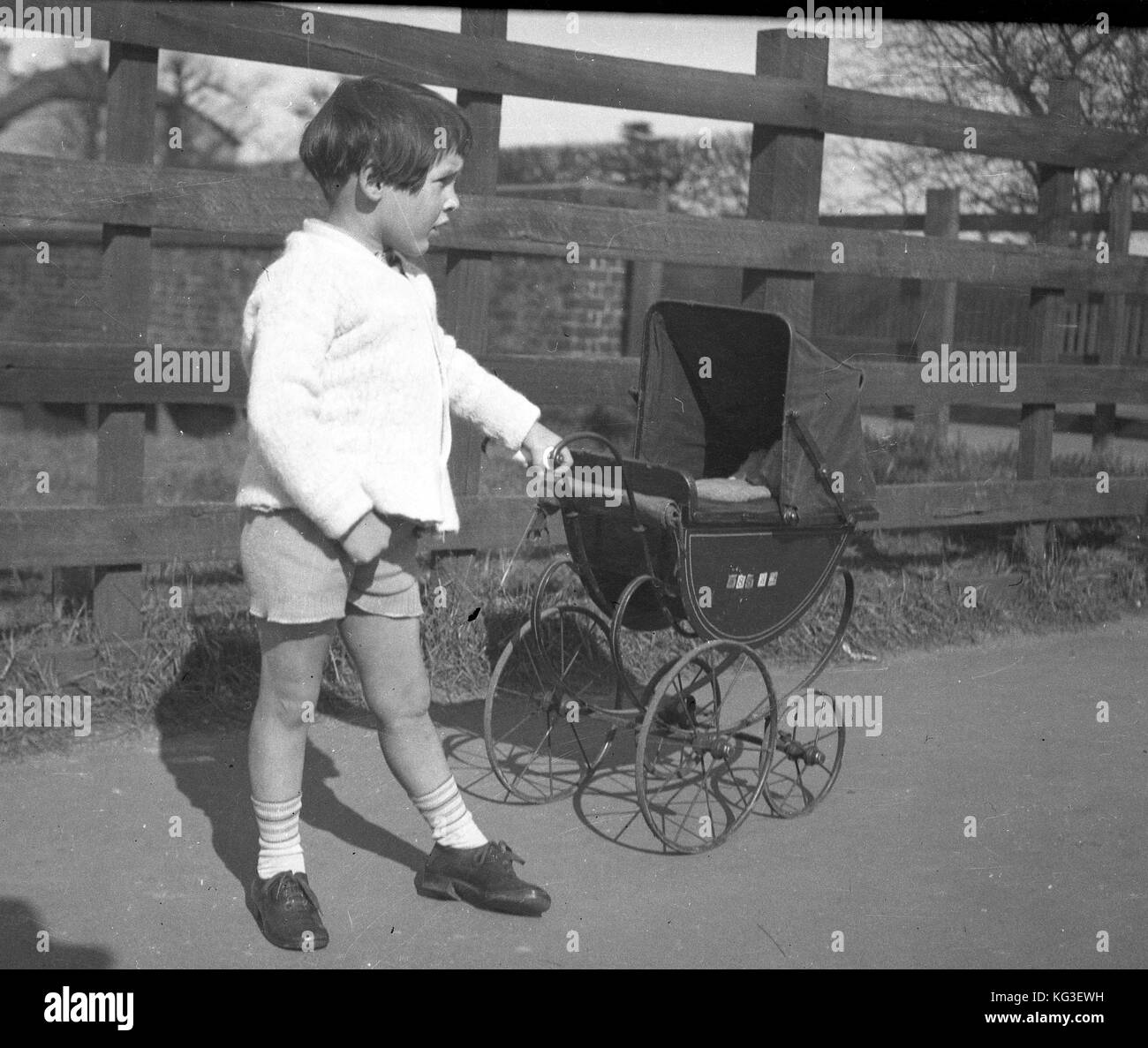 A small girl with her toy pram in the early to mid 1930's.  Photograph by Tony Henshaw Stock Photo