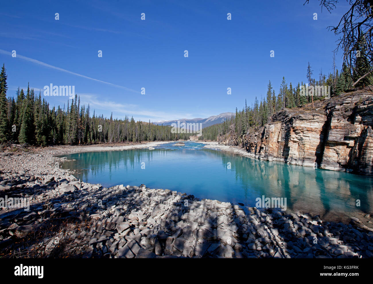 a calm turquoise lake through the Athabasca River in Jasper Park, Alberta Stock Photo