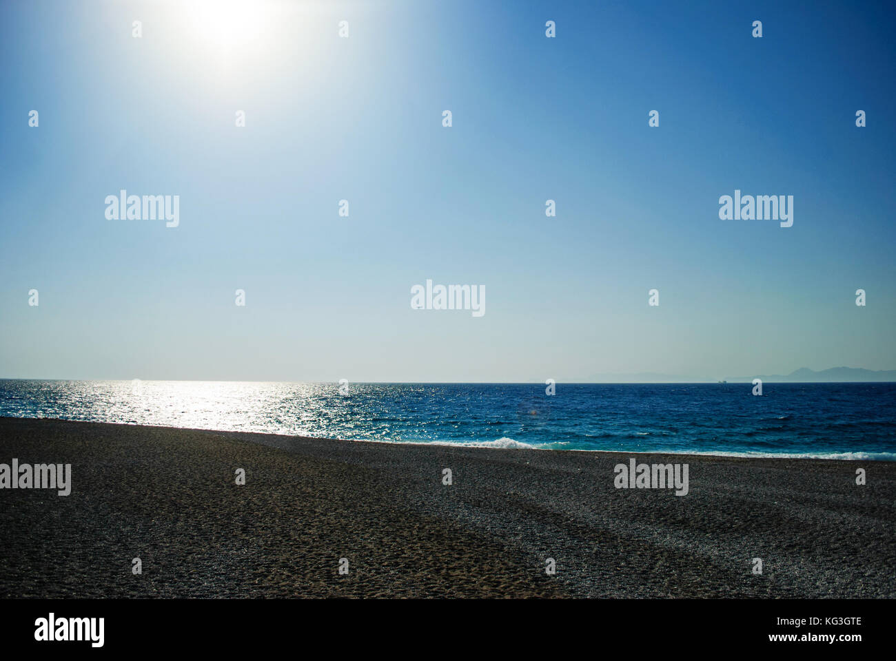The blue sea, the coast and the beautiful sunny day.  Strength of the sun that makes a strong contrast between the sky and the coast Stock Photo