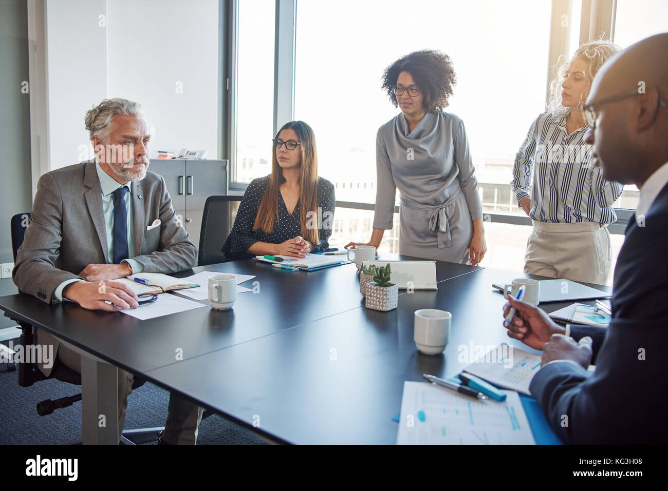 Mature manager talking to a diverse group of employees during a meeting