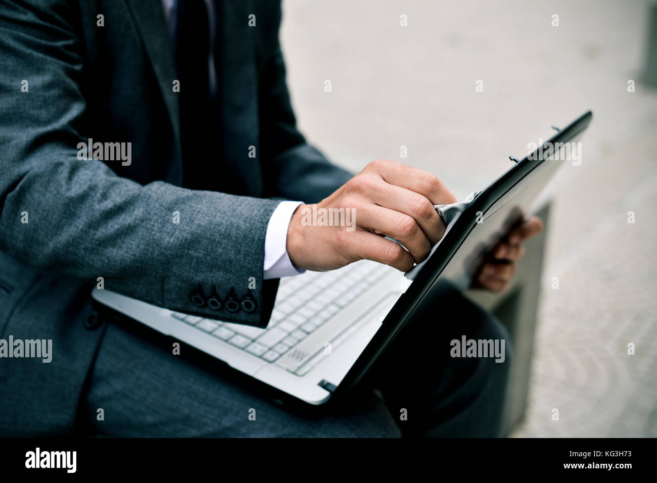 closeup of a young caucasian businessman in a gray suit cleaning the ...