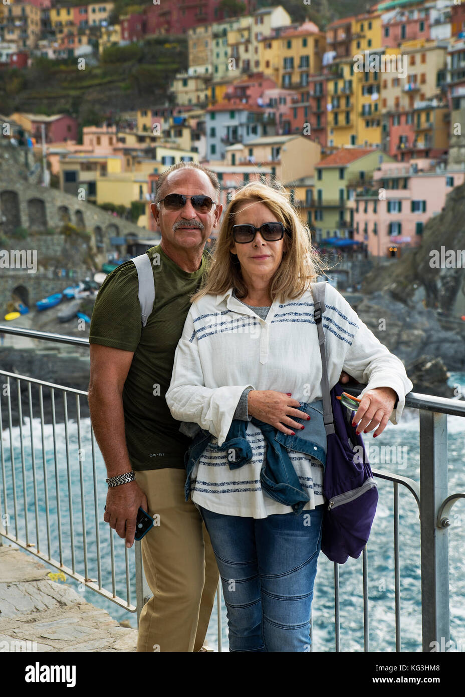 Couple poses for a snapshot while traveling, in Riomaggiore, Cinque Terre, Italy. Stock Photo