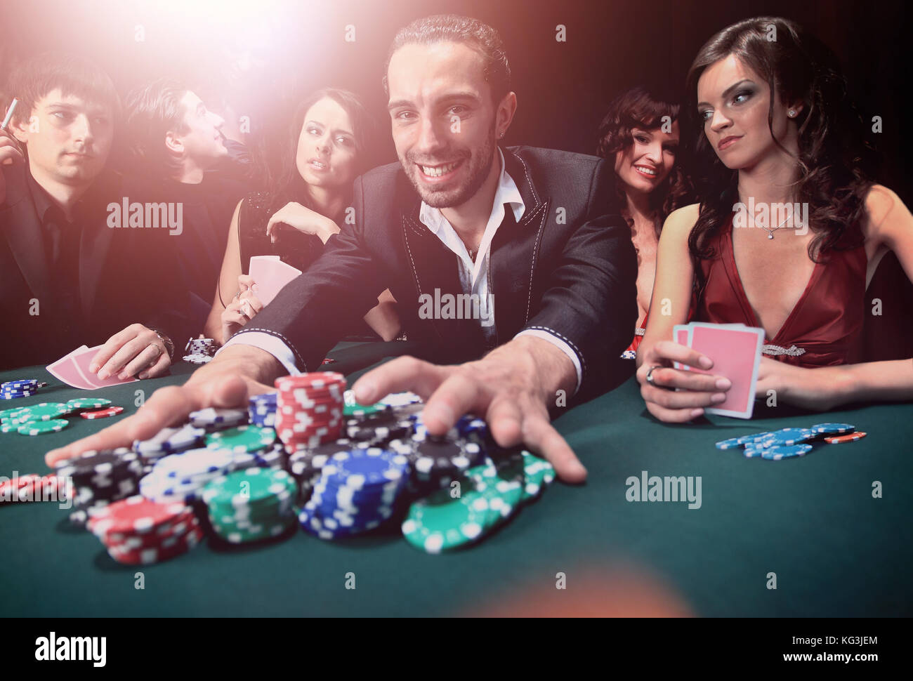 Poker player going "all in" pushing his chips forward Stock Photo - Alamy