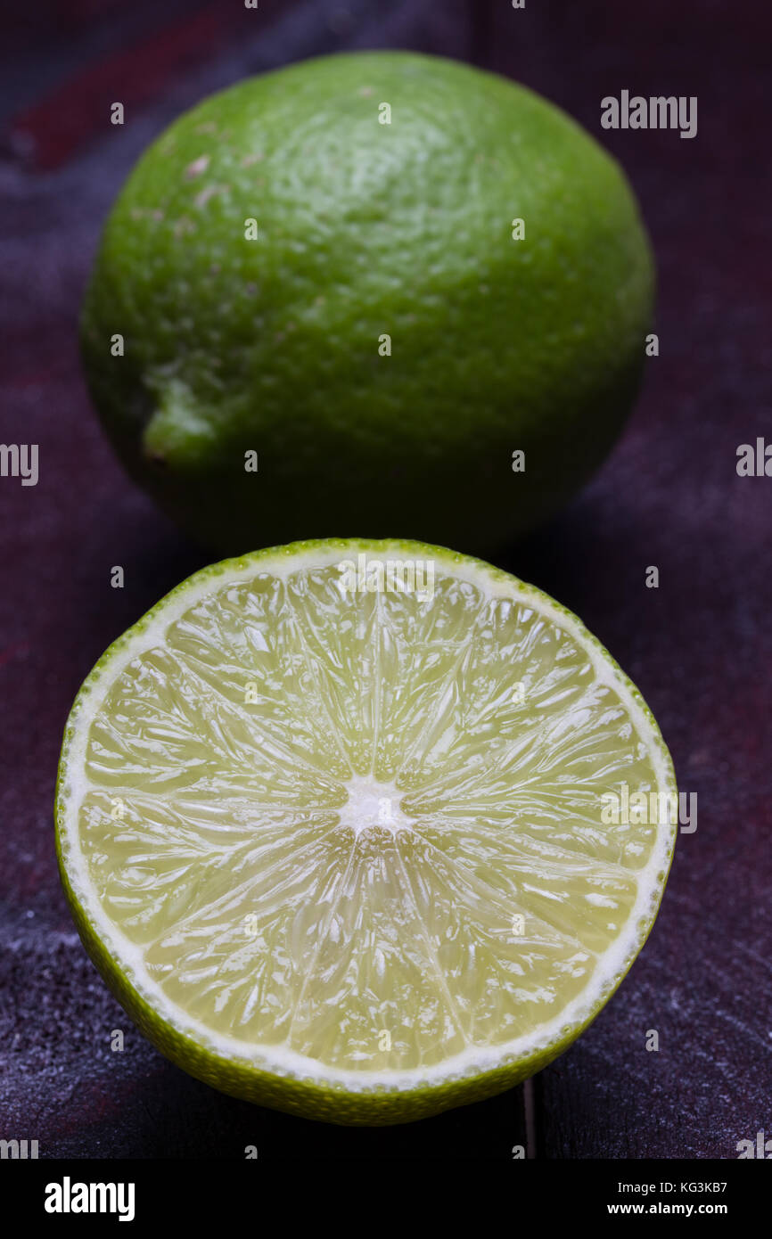 Lime cut open on mahogany wood background Stock Photo Alamy