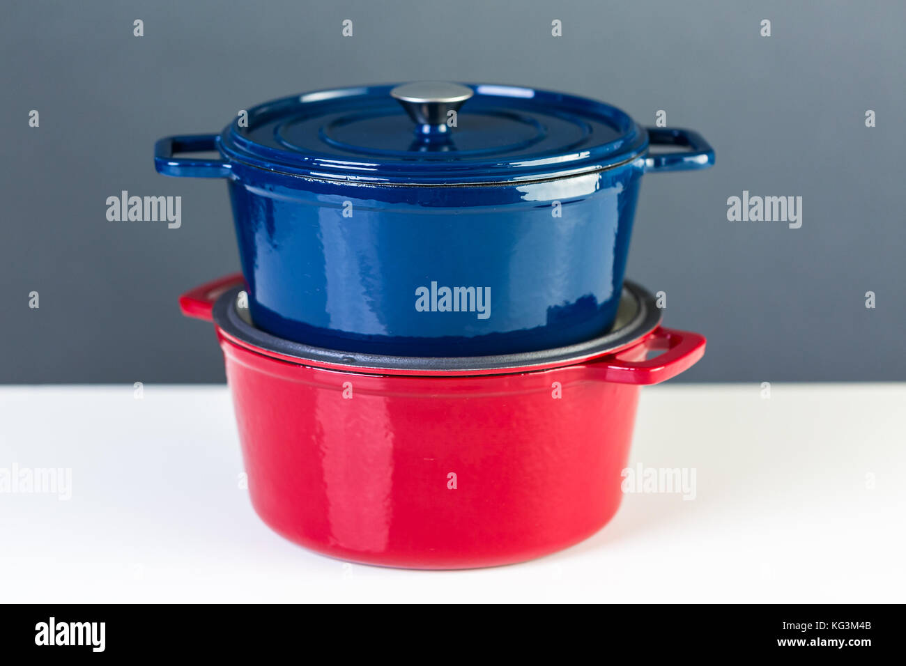 Red and blue enameled cast iron covered dutch ovens on a white background Stock Photo Alamy