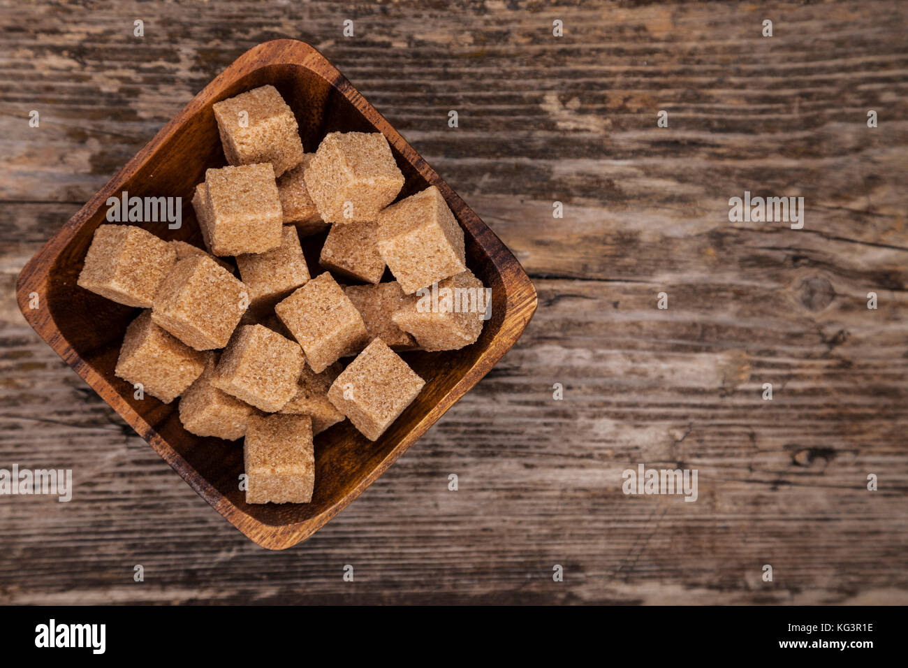 Bowl of brown sugaron an old wooden background, top view Stock Photo