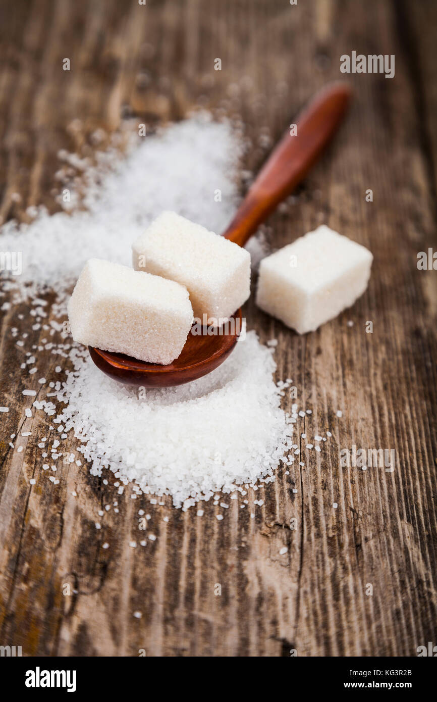 Wooden spoon with sugar on an old wooden background Stock Photo