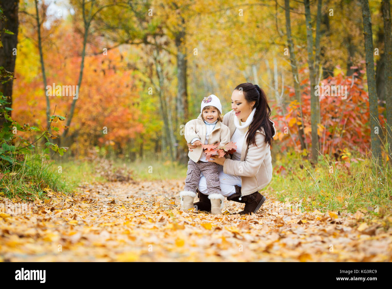 Little girl and her mother playing in the autumn park Stock Photo - Alamy