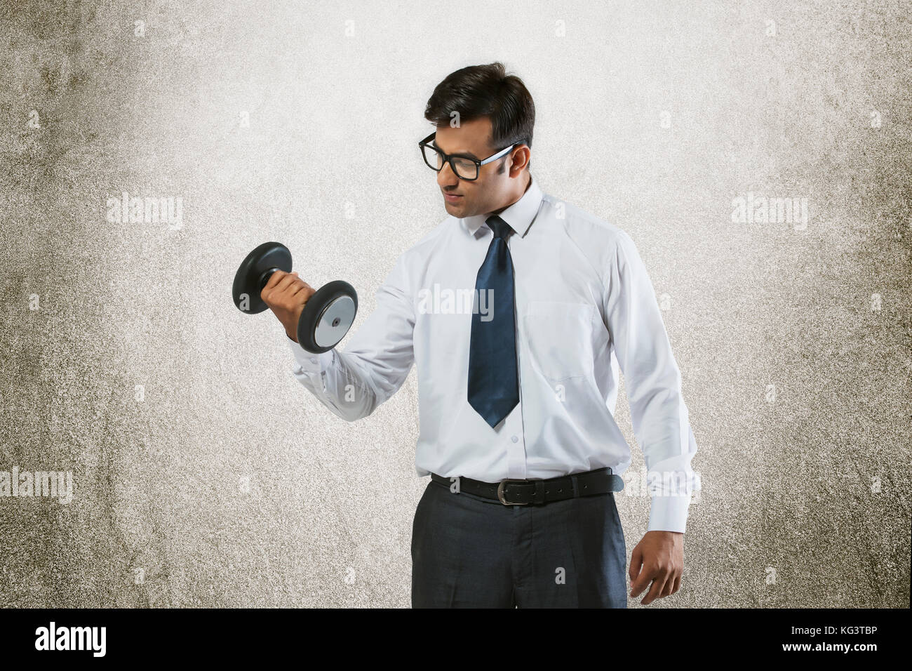 Young businessman lifting weights Stock Photo