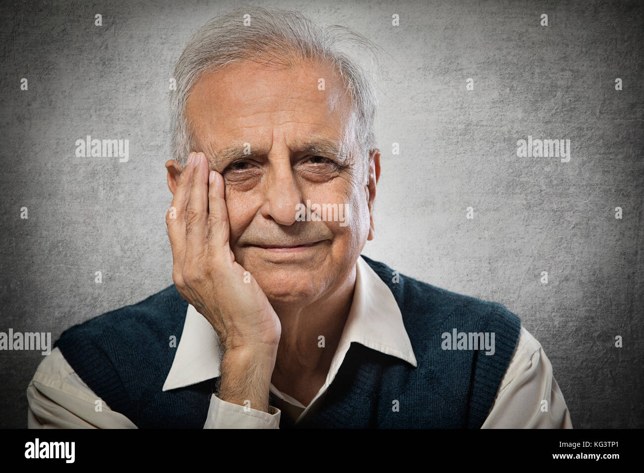 Portrait of smiling senior man with hand on face Stock Photo