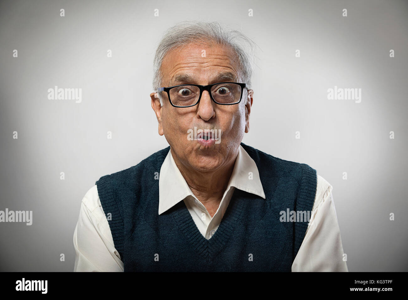 Senior man wearing spectacles making funny face Stock Photo