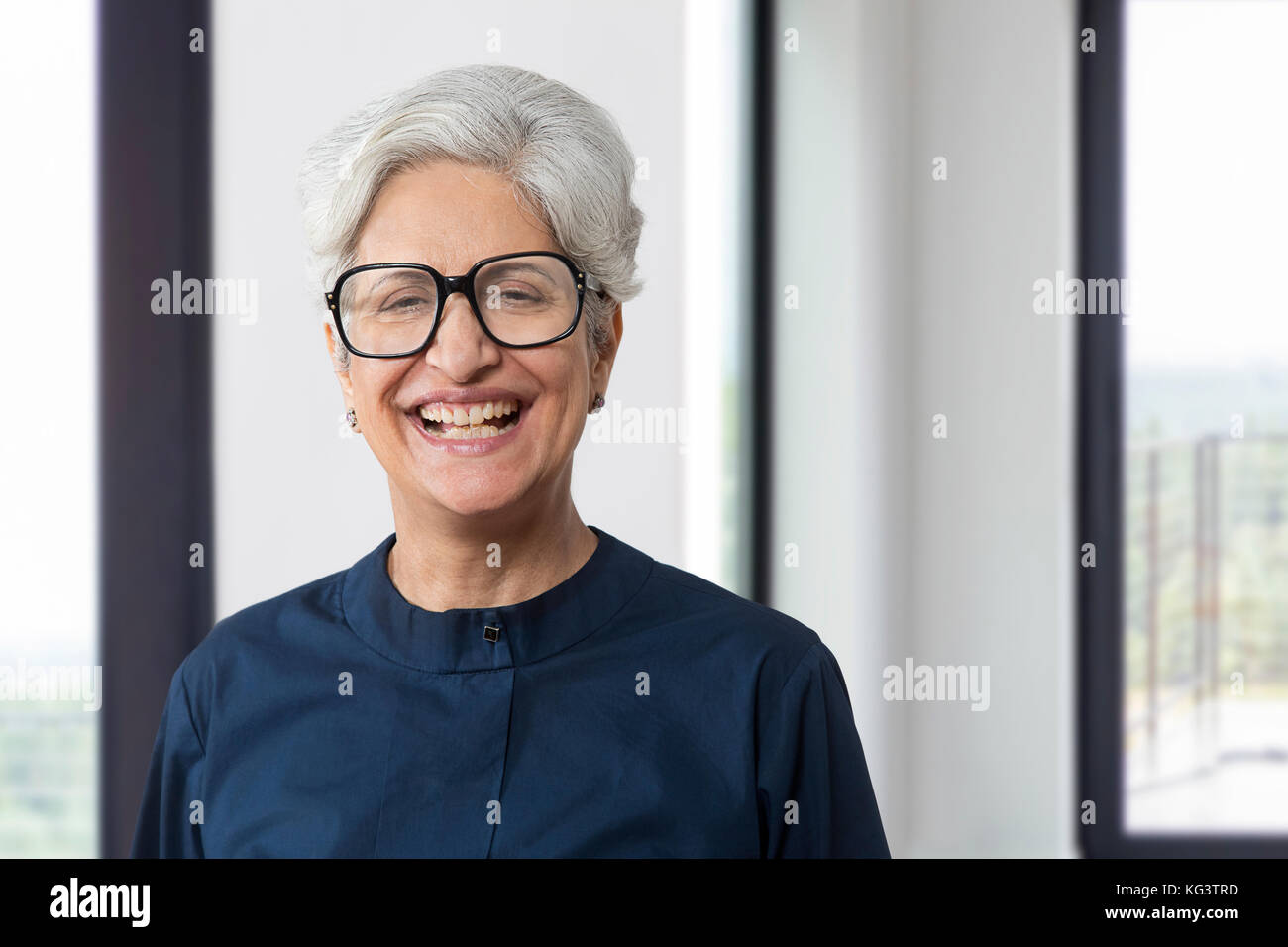 Portrait of smiling senior woman wearing eye glasses Stock Photo