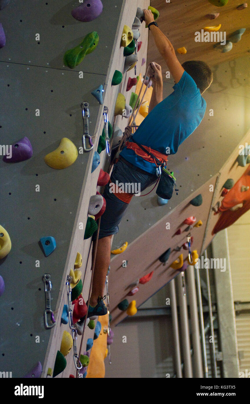 Man Climbing with Ropes on Climbing Wall Stock Photo
