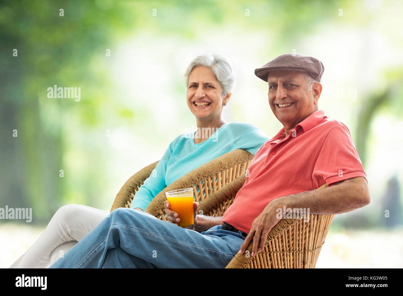 Senior couple sitting outdoors on wicker chair Stock Photo