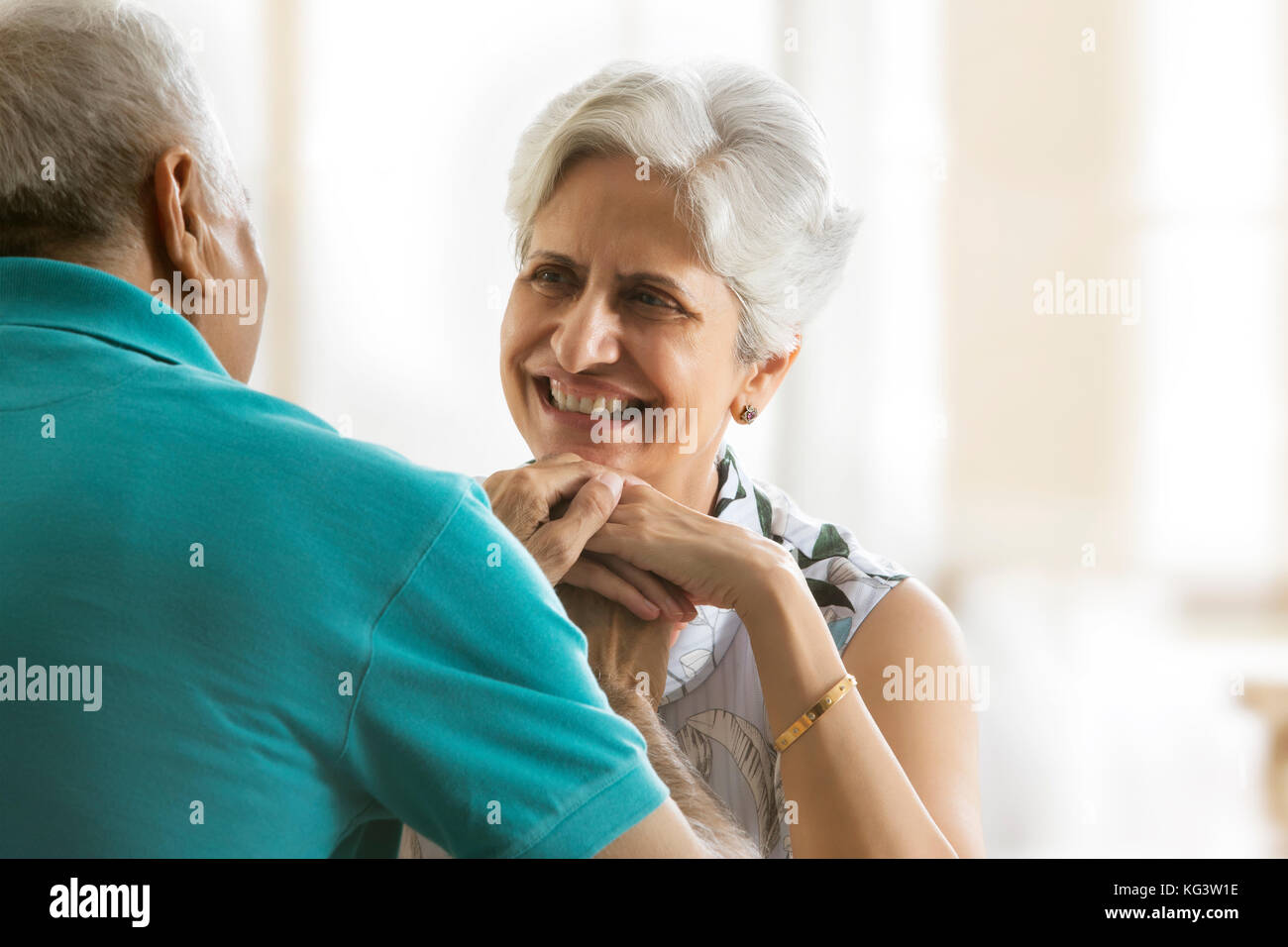Senior couple holding hands sitting at table Stock Photo