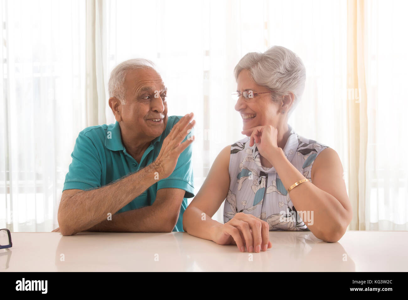 Senior couple talking sitting at table Stock Photo