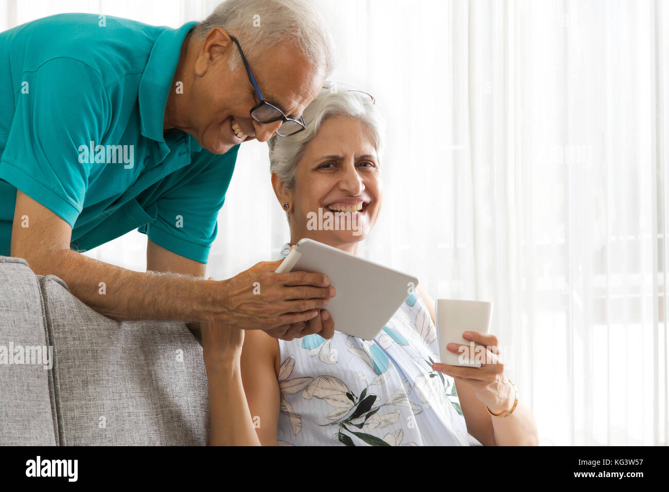 Senior man showing digital tablet to senior woman Stock Photo