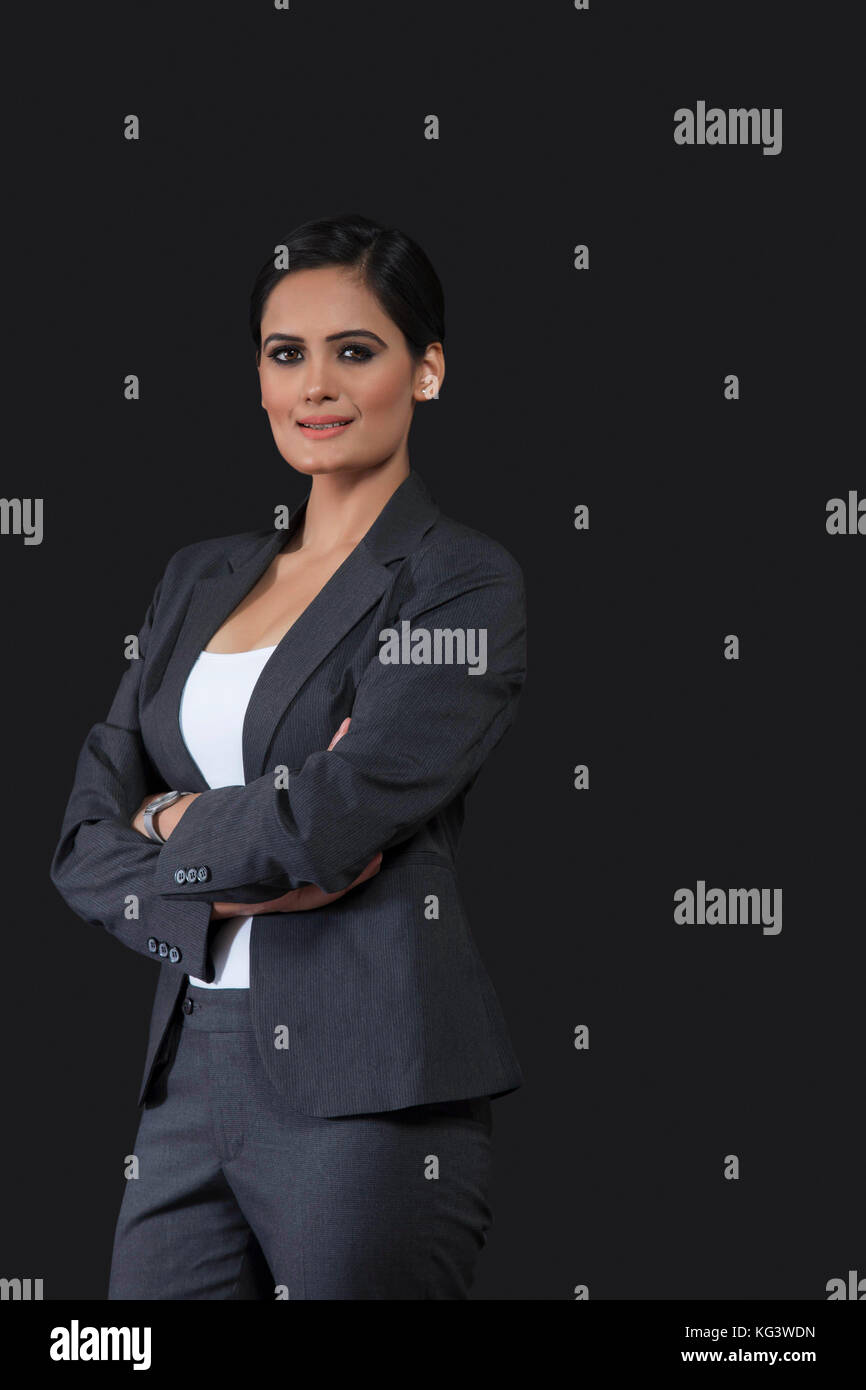 Portrait of young business woman standing with arms crossed Stock Photo