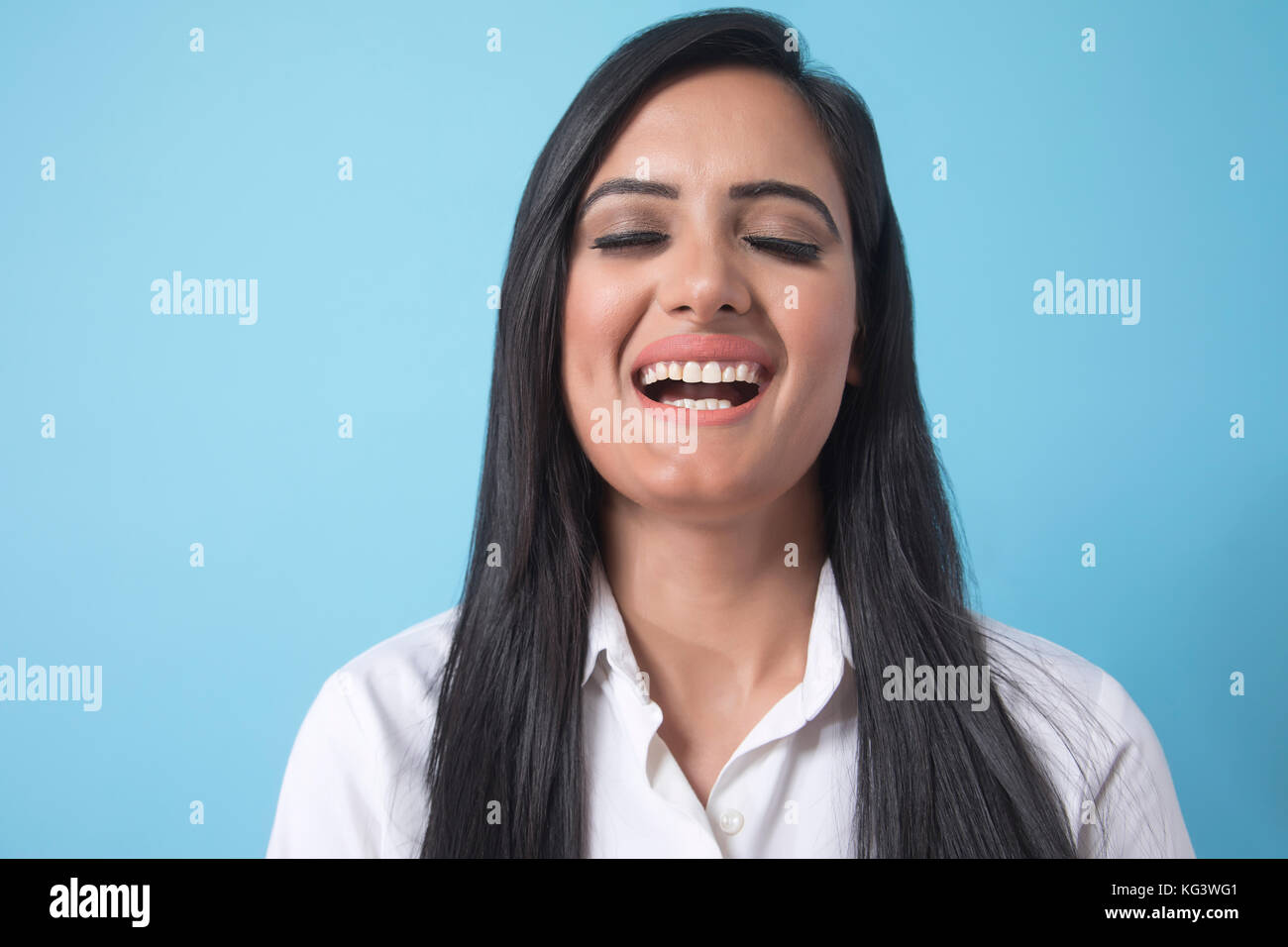 Portrait of smiling businesswoman over blue background Stock Photo
