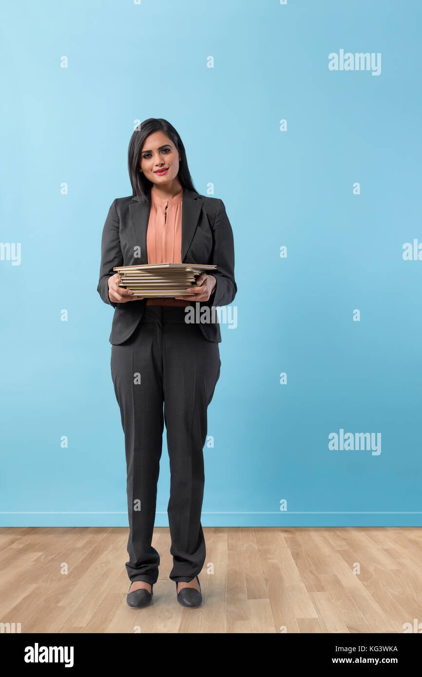 Young business woman in suit holding books Stock Photo