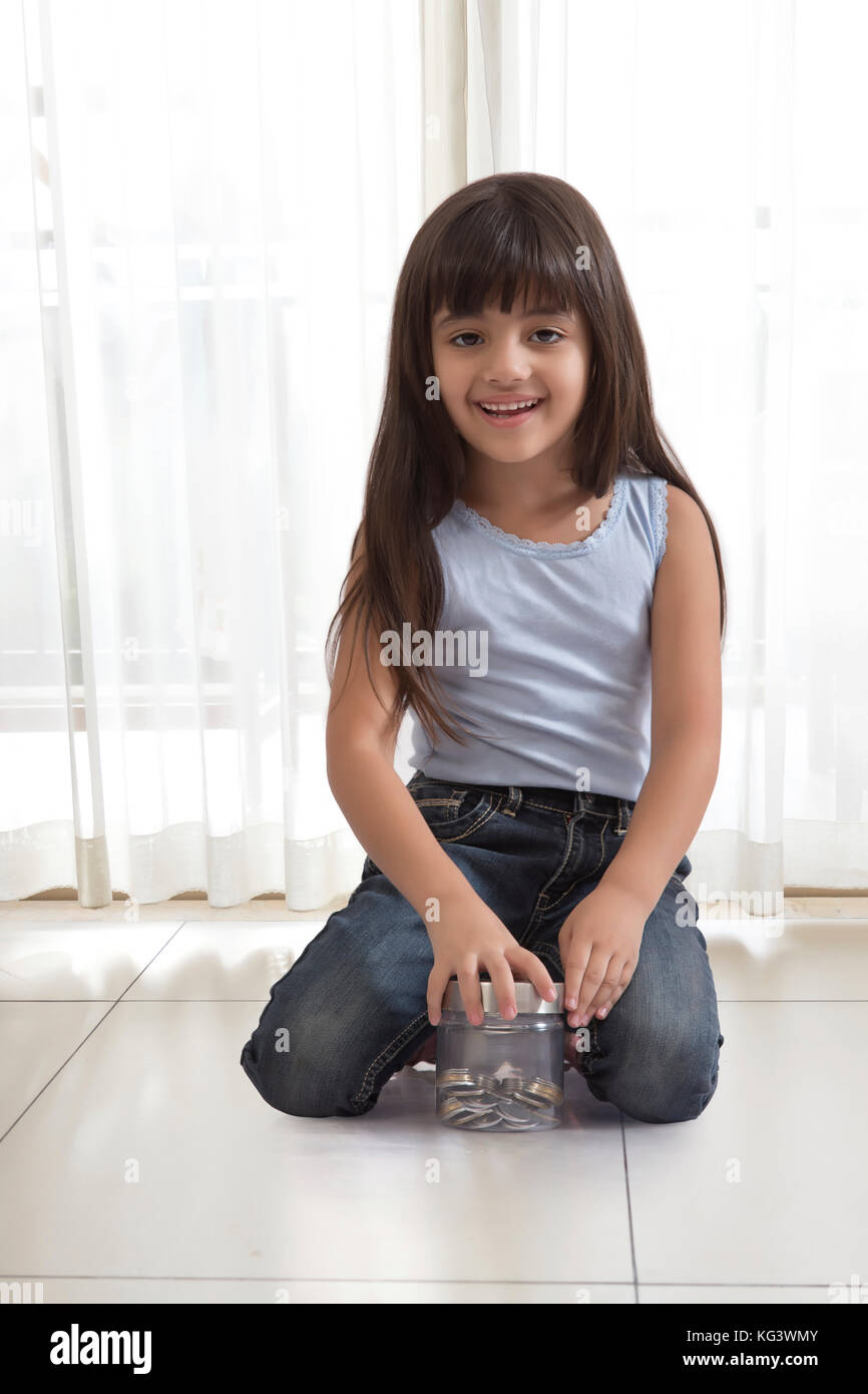 little girl holding coin box Stock Photo