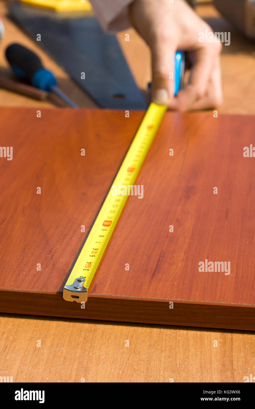 Marking distances. The carpenter's hands measure distance measure Stock